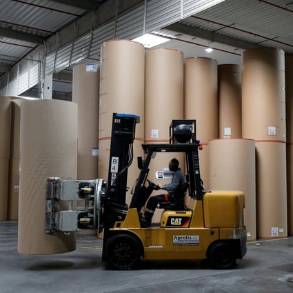 An employee transports a giant reel of paper at the carboard box manufacturing company DS Smith Packaging Atlantique in La Chevroliere, France. Photo: Reuters