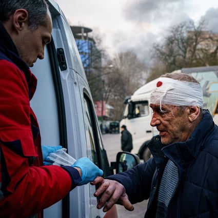 A rescue worker helps an injured man after Russian shelling on the Ukrainian city of Kherson on Saturday. Photo: AFP