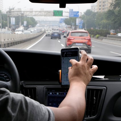 A ride-hailing driver looking at maps direction from a smartphone in Beijing. Photo: Reuters