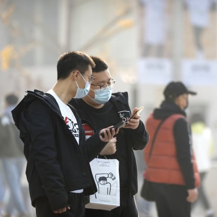 People look at their smartphones in Wangfujing shopping district in Beijing, on November 19. Photo: AP