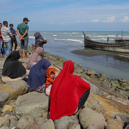 Villagers look at a wooden boat used by Rohingya people in Pidie, Aceh province on December 27, 2022. Photo: AFP