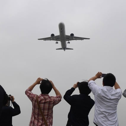 Spectators take photos of a Chinese passenger jet. Malaysia has said it will test the waste water off flights from China for Covid-19, but not the passengers. Photo: AFP
