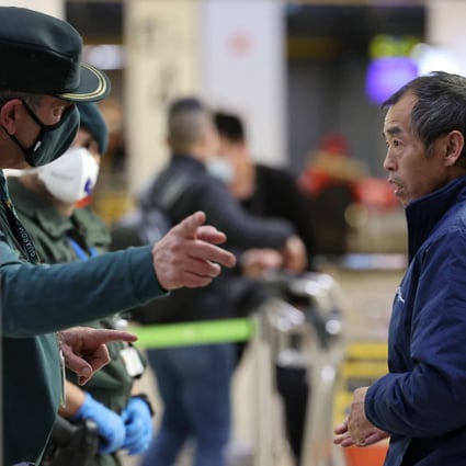 A passenger who arrived on a flight from Beijing listens to indications from a Civil Guard after landing at Spain’s Adolfo Suarez Madrid-Barajas airport on Saturday. Photo: AFP