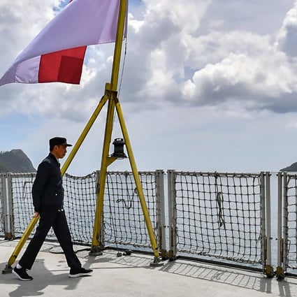 Indonesia’s President Joko Widodo walking past the country’s flag on a navy ship during his visit to a military base in the Natuna islands, which border the South China Sea. Photo: Indonesian Presidential Palace/AFP