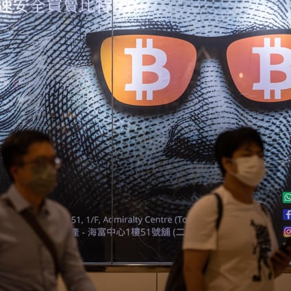 People walk past an advertising poster for Bitcoins and cryptocurrencies in Hong Kong in September 2021. Photo: EPA-EFE