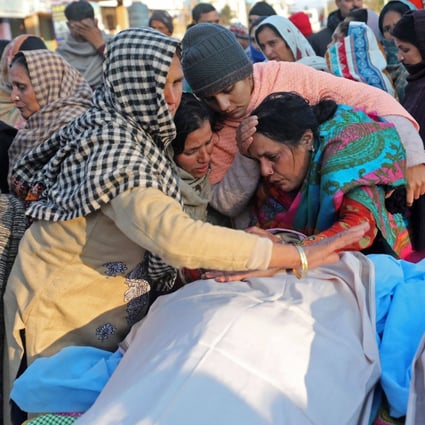 Family members mourn next to the bodies of loved ones killed after gunmen opened fire on houses in a remote Kashmir village. Photo: AFP