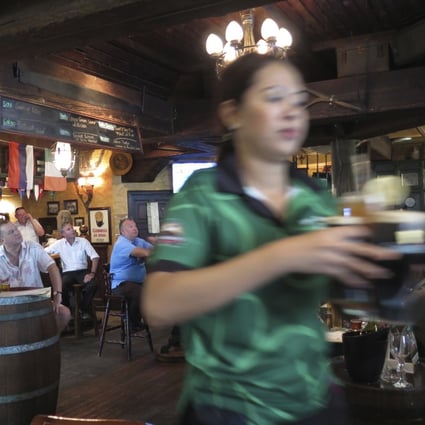 A waitress serves customers beer at a restaurant in Dubai. Dubai ended its 30 per cent tax on alcohol sales in the sheikhdom on January 1 and made its required liquor licenses free to obtain, ending a long-standing source of revenue for its ruling family to apparently further boost its tourism to the emirate. Photo: AP
