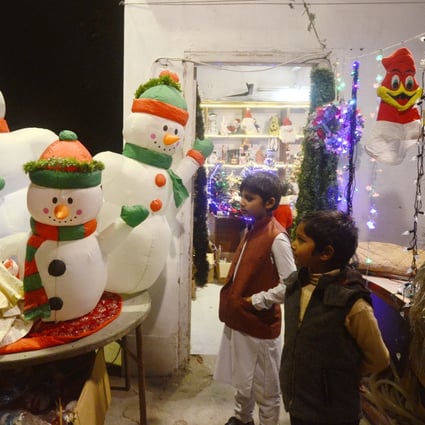 Children visit a Christmas decoration shop in Peshawar in December 2022. Pakistan has ordered all malls and markets to close by 8.30pm as part of a new energy conservation plan. Photo: Xinhua