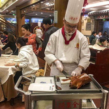 Chef carving a Peking duck in a Quanjude restaurant in Beijing. Photo: Elaine Yau