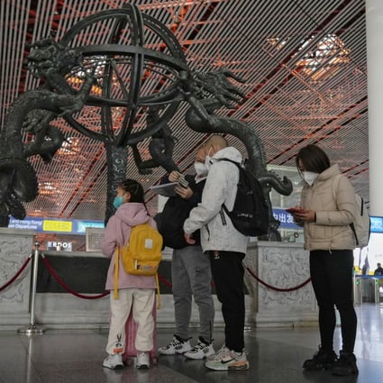 A family check their passports before entering an international departure gate at Beijing Capital International Airport last month. Photo: AP