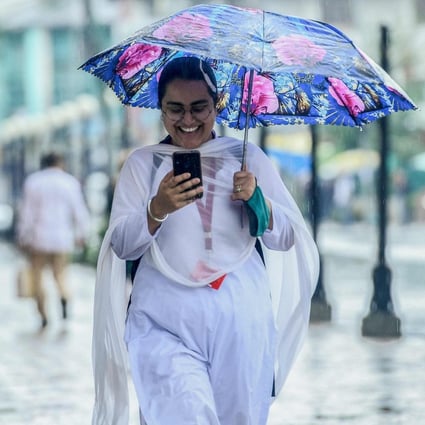 A commuter checks her mobile phone in Srinagar, India. Photo: AFP