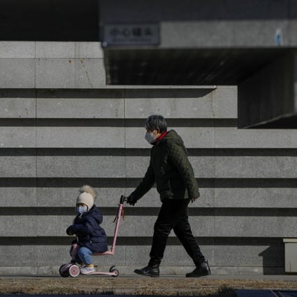 An elderly woman pushes a child on a scooter at a public park in Beijing on December 19. More than 50 per cent of all Chinese grandparents provide care for their grandchildren, compared with around 4 per cent of American grandparents who do. Photo: AP