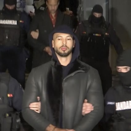 Divisive social Media personality Andrew Tate is led away by police in Romania on Thursday. Photo: Observator Antena 1 via AP