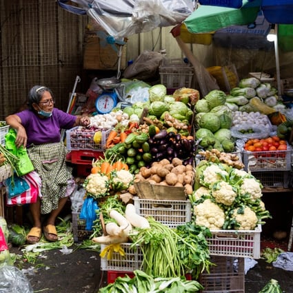 A vegetable vendor tends to her store at a public market in Manila last month. Onion prices in the Philippines have been pushed higher by a drop in local output. Photo: Reuters