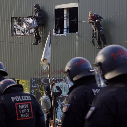 Police approach activists hanging on ropes from a building in the village of Luetzerath, Germany, where they are protesting about the reopening of a coal mine. Photo: EPA-EFE