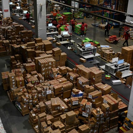 Workers sort packages for delivery at a JD.com warehouse in Beijing on January 10. With further fiscal and monetary support, China’s economy should see a stronger rebound in the second half of the year. Photo: AFP