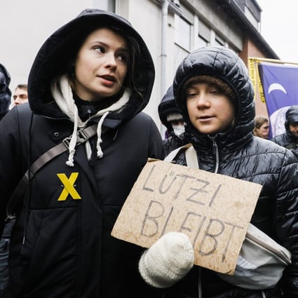 Swedish climate activist Greta Thunberg (right) holding a placard reading “Luetzi stays” is joined by  German climate activist Luisa Neubauer (left) as they attend a rally of climate protection activists near the village of Luetzerath in Germany on January 14, 2023. Photo: EPA-EFE
