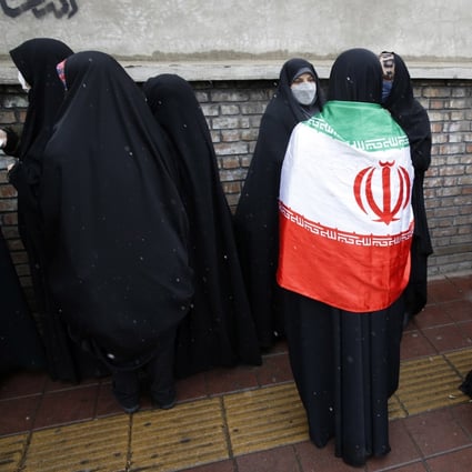 A woman wears the Iranian national flag during a protest outside the French embassy in Tehran, Iran on January 11, 2023. Photo: EPA-EFE
