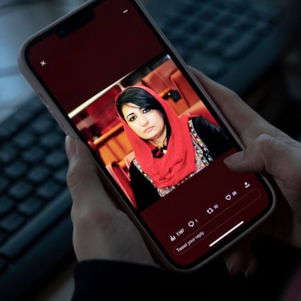 A woman looks at a photo of former Afghan lawmaker Mursal Nabizada on her mobile phone. Nabizada was shot dead by gunmen at her house in Kabul. Photo: AFP