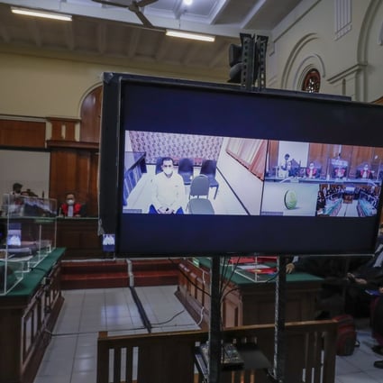 A defendant is presented virtually on a screen during the first trial of the Kanjuruhan stadium deadly stampede at the courthouse in Surabaya, East Java, Indonesia. Photo: EPA-EFE