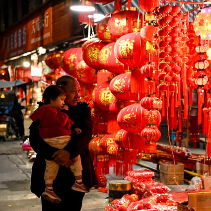 Shoppers walk past Chinese Lunar New Year decorations for sale in the border city of Ruili. Photo: AFP