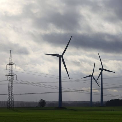 Wind turbines and high voltage electricity transmission towers in Germany. Investments in renewables need to triple by 2030 if climate targets are to be met, experts have warned. Photo: Bloomberg