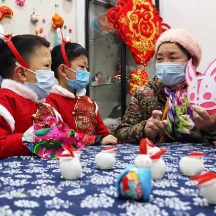 Children learn about culture from a woman in preparation for the Year of the Rabbit in Huzhou, China. Lunar New Year celebrations often include the wearing of red-coloured clothing – but some traditions are rarely observed any more. Photo: Getty Images