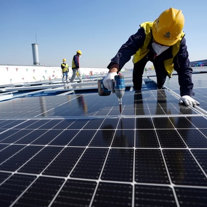 A worker installs photovoltaic power panels on the roof of a factory in Tangsha, in north China’s Hebei province. Photo: Xinhua