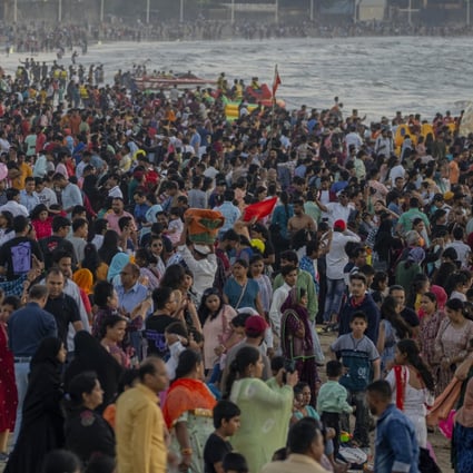 People crowd a beach in Mumbai on December 31 to watch the last sunset of 2022. India’s population stood at an estimated 1.417 billion as of the end of last year. Photo: AP