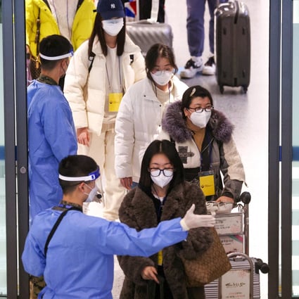 A soldier wearing personal protective equipment directs a group of Chinese tourists to a Covid-19 testing centre after their arrival at Incheon International Airport in South Korea on January 4. Photo: Reuters