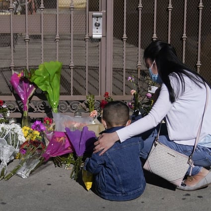 A woman comforts her son while visiting a makeshift memorial outside Star Ballroom Dance Studio in Monterey Park, California, on Monday. Photo: AP