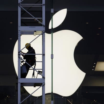 A worker climbs on scaffolding in front of the Apple logo at one of the US technology company’s stores in Hong Kong. Photo: Reuters