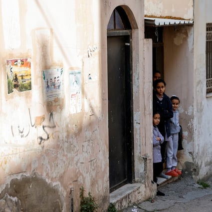 Palestinian children look out of their homes following an Israeli raid in Jenin. Photo: Reuters