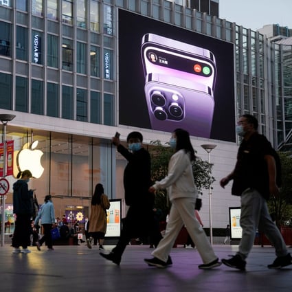 People walk near a display advertising Apple’s iPhone 14 outside its store in Shanghai on November 7, 2022. Photo: Reuters