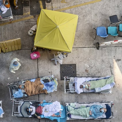 Patients showing Covid-19 symptoms lie on beds outside the Accident and Emergency Department at Caritas Medical Centre in Hong Kong on February 15, 2022. Photo: EPA-EFE
