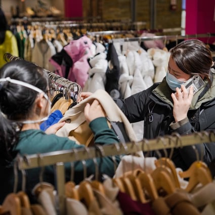 People choose clothes at Joy City shopping centre in Beijing on January 31. There are fears the increase in household savings in China reflects economic uncertainty rather than pent-up demand. Photo: EPA-EFE