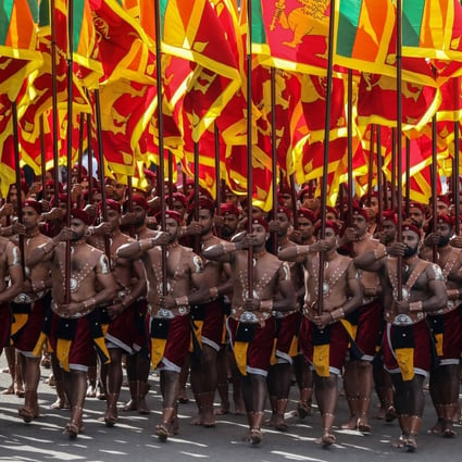 Sri Lankan soldiers, dressed in traditional costumes, march with national flags during the 75th Independence Day parade in Colombo. Photo: EPA-EFE