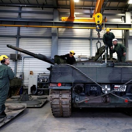 A Polish army instructor wearing a white helmet talks to Polish soldiers during a Leopard 2 tank repair training in Swietoszow, Poland on Tuesday. Photo: Reuters 