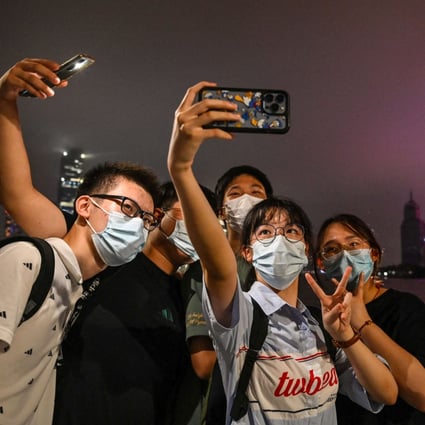 Young people pose for a selfie on the Bund promenade in Shanghai on August 23, 2022. Photo: AFP