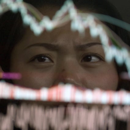 An investor is reflected on an electronic screen showing stock information at a brokerage in China. Photo: Reuters