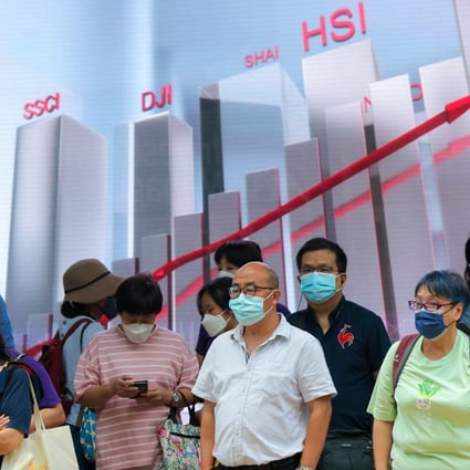 People pass a display showing the Hang Seng Index and other indices in Central, Hong Kong on October 5, 2022. Photo: Jelly Tse
