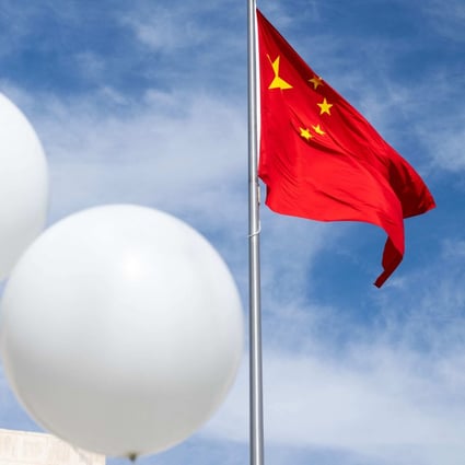 Two white balloons float near the Chinese flag as American activist Reverend Patrick Mahoney protests against the Chinese government outside the Chinese embassy in Washington on February 15 after a Chinese “balloon” was shot down over the US last week. Photo: AFP