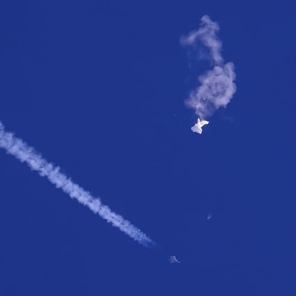 A fighter jet flies past the remnants of a large balloon after it was shot down above the Atlantic Ocean, just off the coast of South Carolina on February 4. Photo: Chad Fish via AP