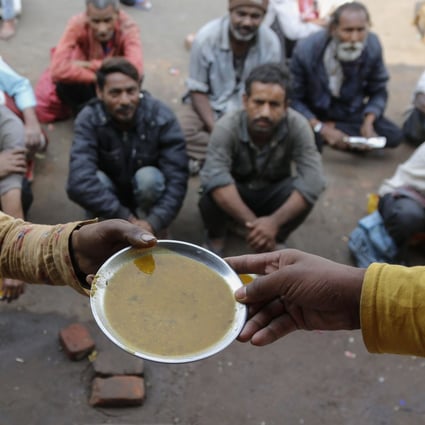 People wait for free food outside an eatery in Ahmedabad, India, on January 20, 2021. While globalisation has benefited a handful of countries, it has exacerbated the inequality and marginalisation of poorer regions of the world. Photo: AP