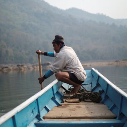A local villager steers a boat where the future site of the Luang Prabang dam will be on the Mekong River. Photo: Reuters