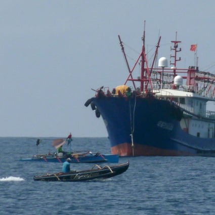 Filipino fishermen aboard their boats sail past a Chinese vessel near the Scarborough Shoal in the disputed South China Sea, on February 6. Rising regional and global tensions threaten to thwart Indonesia’s efforts to revive negotiations over a code of conduct in the South China Sea. Photo: AFP