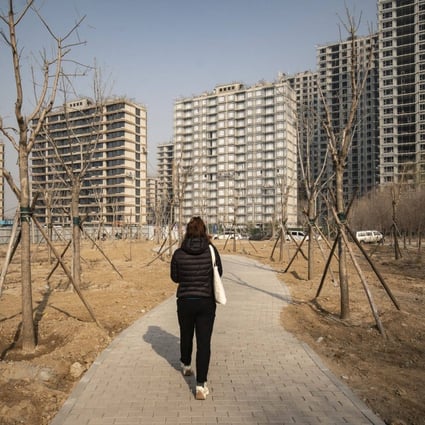 A pedestrian heads towards residential apartments under construction in Beijing on March 4. Tensions between efforts to forestall a financial crisis and the need to reduce leverage and speculation make it extremely difficult to restore confidence in the industry, particularly among homebuyers. Photo: Bloomberg 
