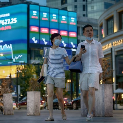 People walk in front of the large screen showing the latest stock exchange data in Shanghai in August 2022. Photo: EPA-EFE