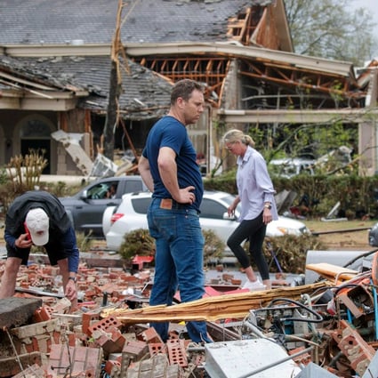 A family search through rubble for belongings after a direct tornado strike to their business in Little Rock, Arkansas.on Friday. Photo: Getty Images North America / AFP