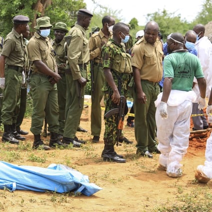 Kenyan homicide detectives and forensic experts from the Directorate of Criminal Investigations examine exhumed bodies from several shallow mass graves of suspected members of a Christian cult after starving themselves to death. Photo:  EPA-EFE